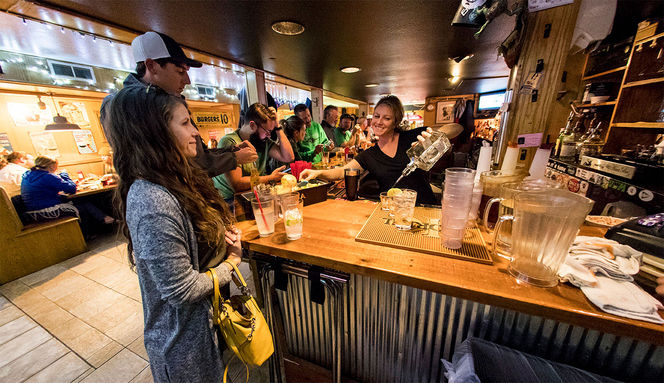 people-enjoying-the-pub-and-bartender-pouring-a-drink-smiling.jpg
